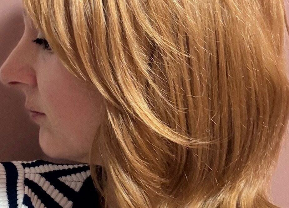 Side profile of a woman with golden layered hair at Hairbysarah, Chichester, England, GB.