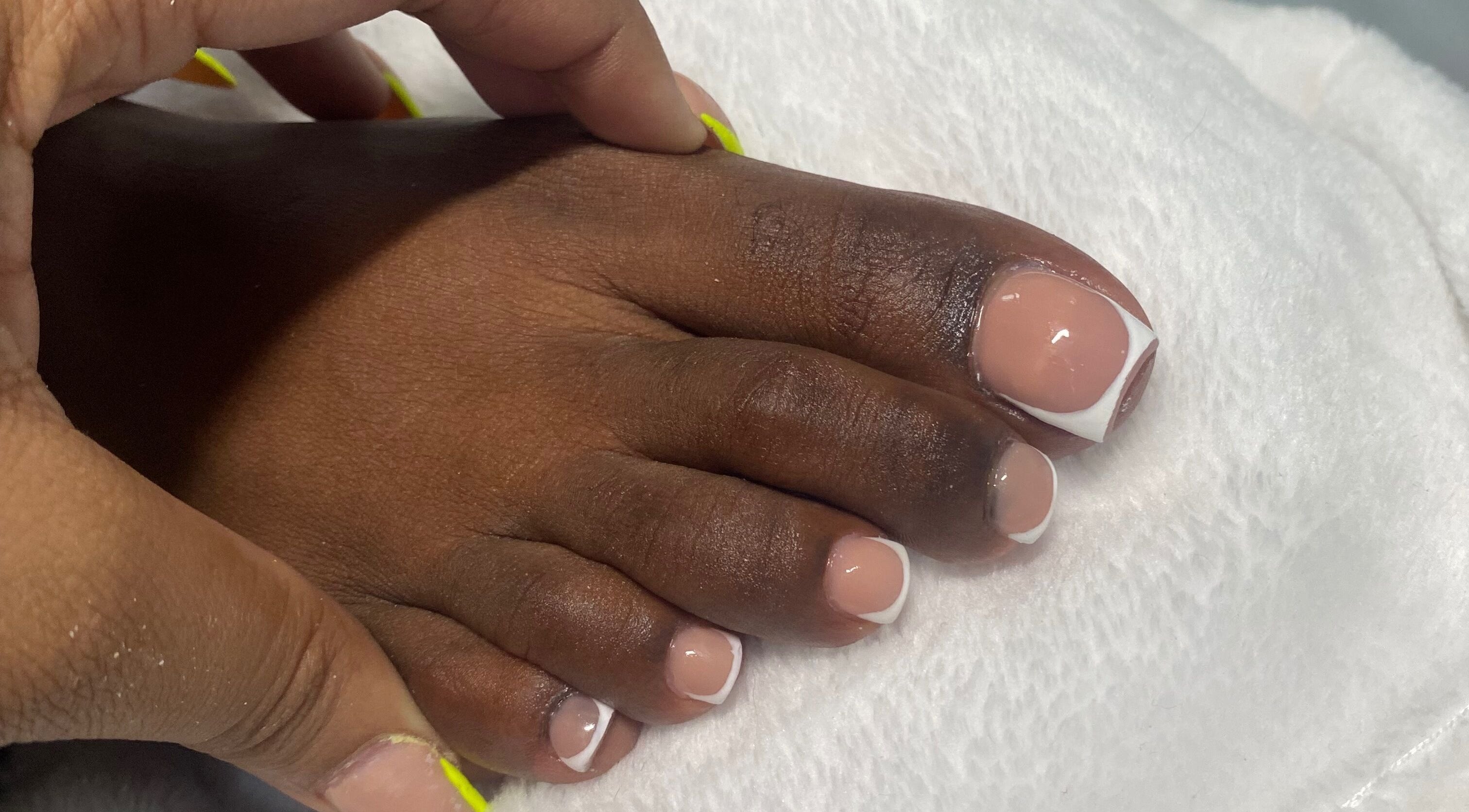 Fresh French pedicure at Reign Nail Studio, Saint Michael, Saint Michael, BB. Perfectly styled toes on white towel.