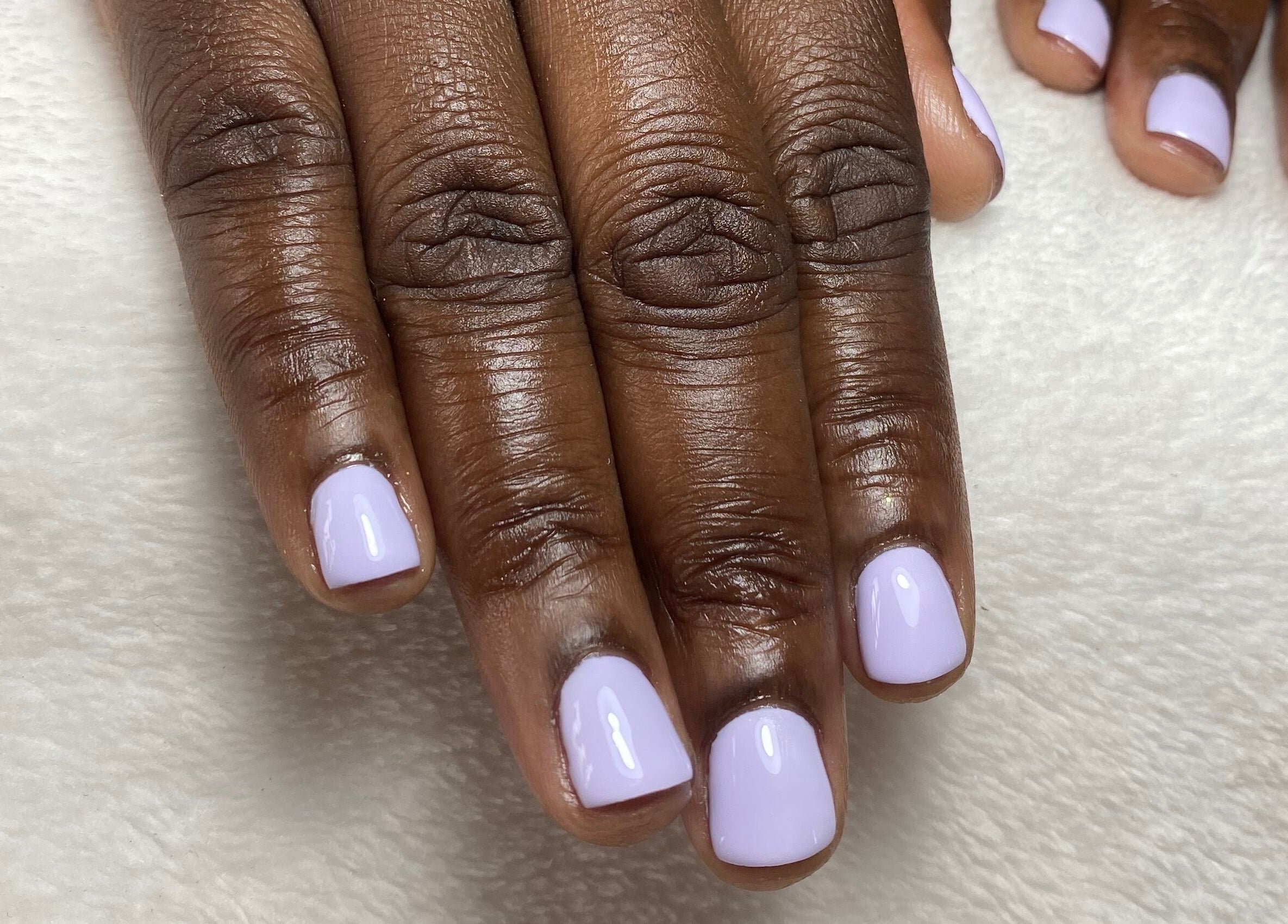 Lavender nail art at Reign Nail Studio, Saint Michael, BB. Perfectly polished nails on a cozy backdrop.