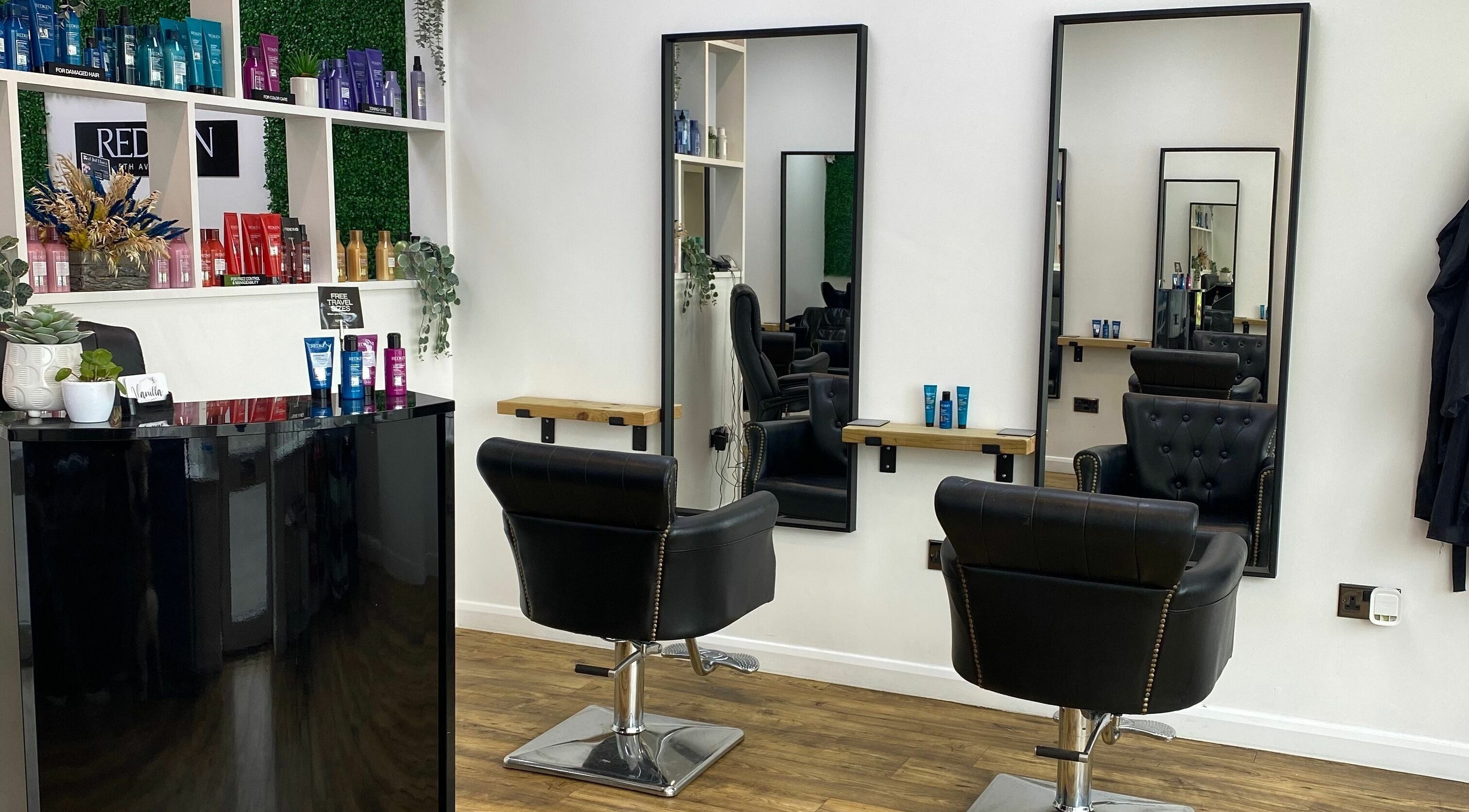 Elegant styling area at Vanilla Hair And Beauty in Portchester, England, GB with black chairs and products.