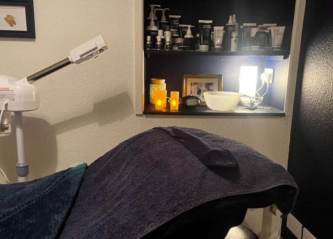 Cozy treatment room at Calmante, Truro, England, GB with warm lighting and beauty products displayed.