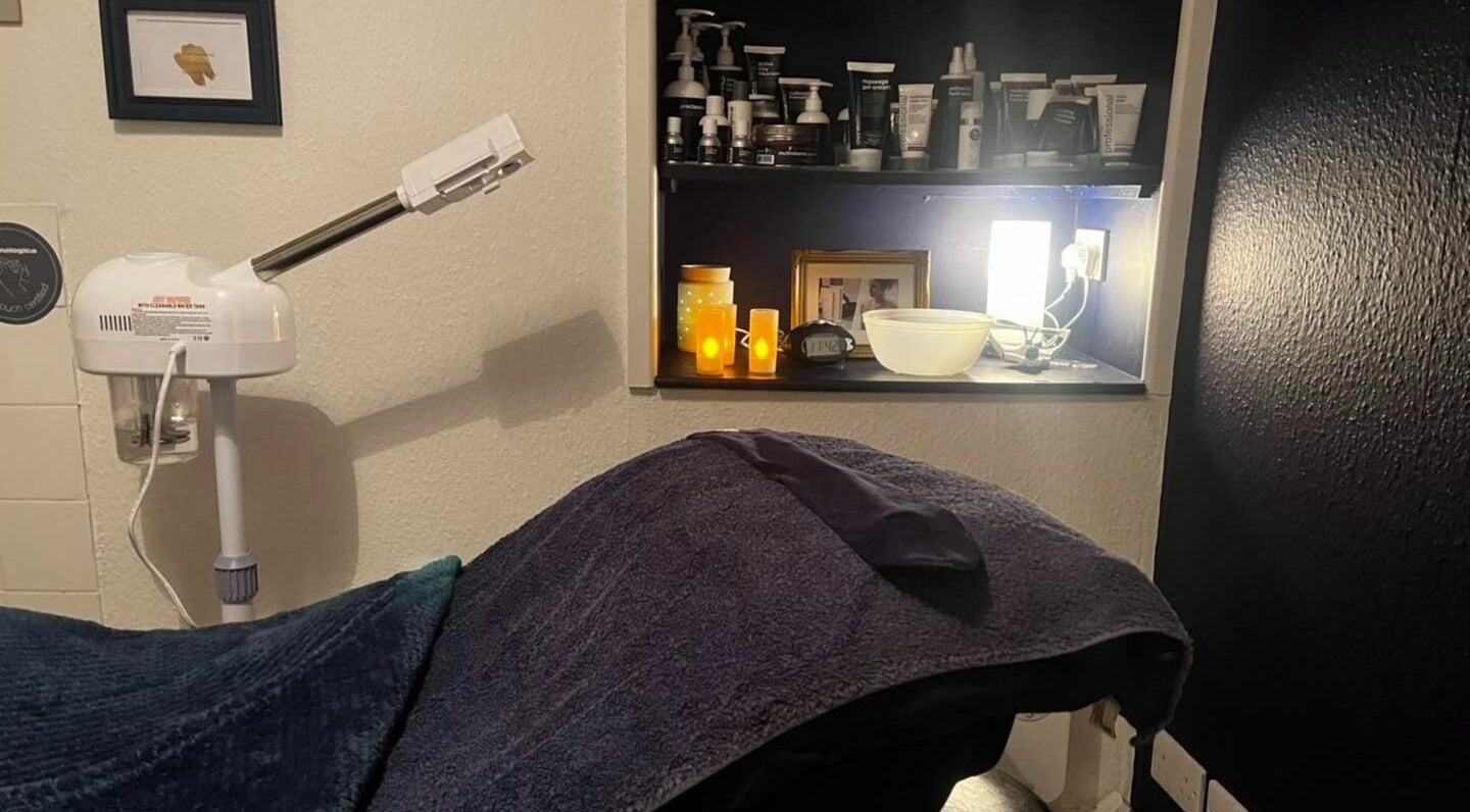 Cozy treatment room at Calmante, Truro, England, GB with warm lighting and beauty products displayed.