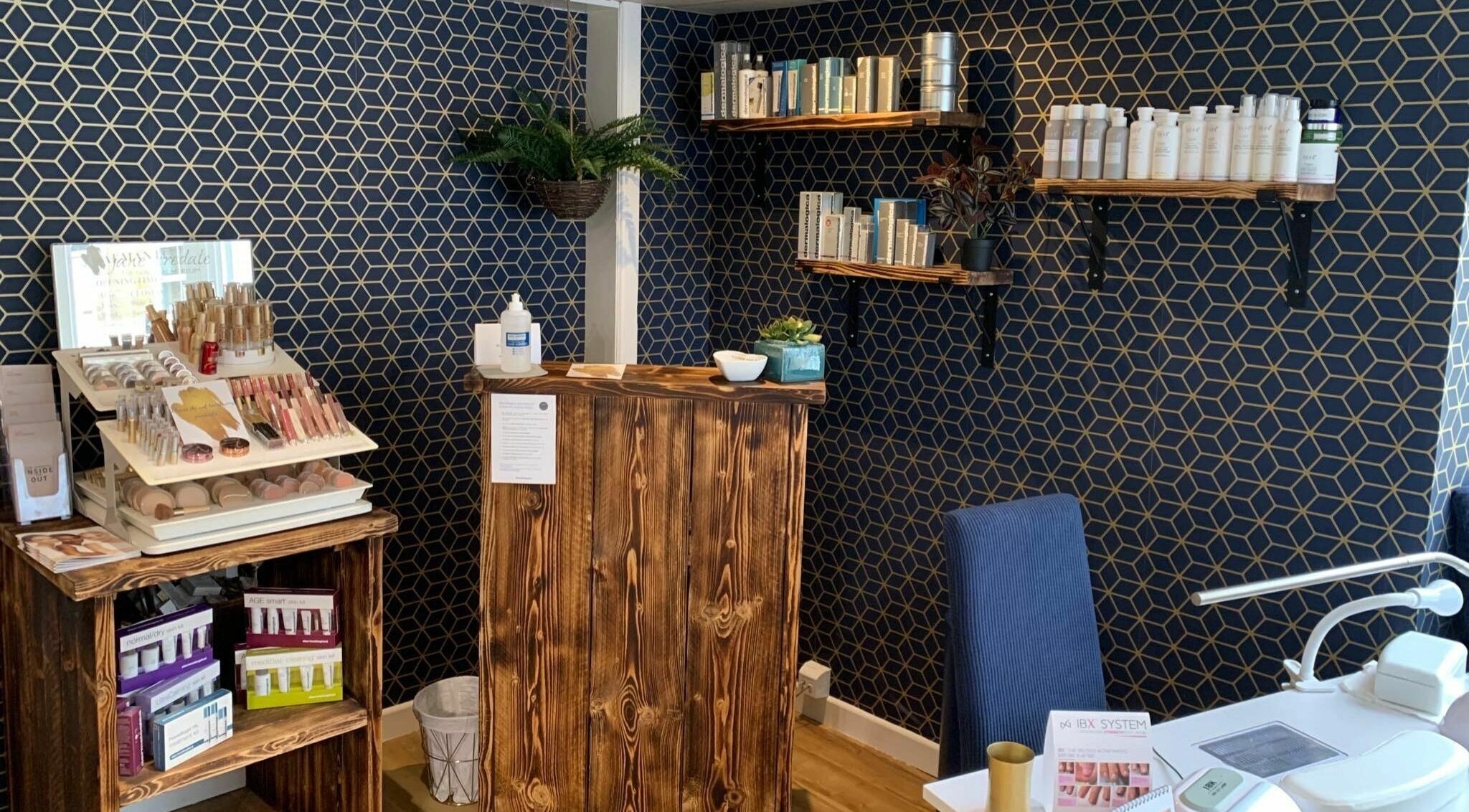 Cozy reception area at Calmante, Truro, England, GB, featuring elegant decor with beauty products displayed.
