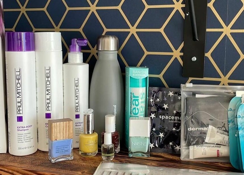 Beauty products display at Calmante, Truro, England, GB, featuring Paul Mitchell shampoo and nail polishes.