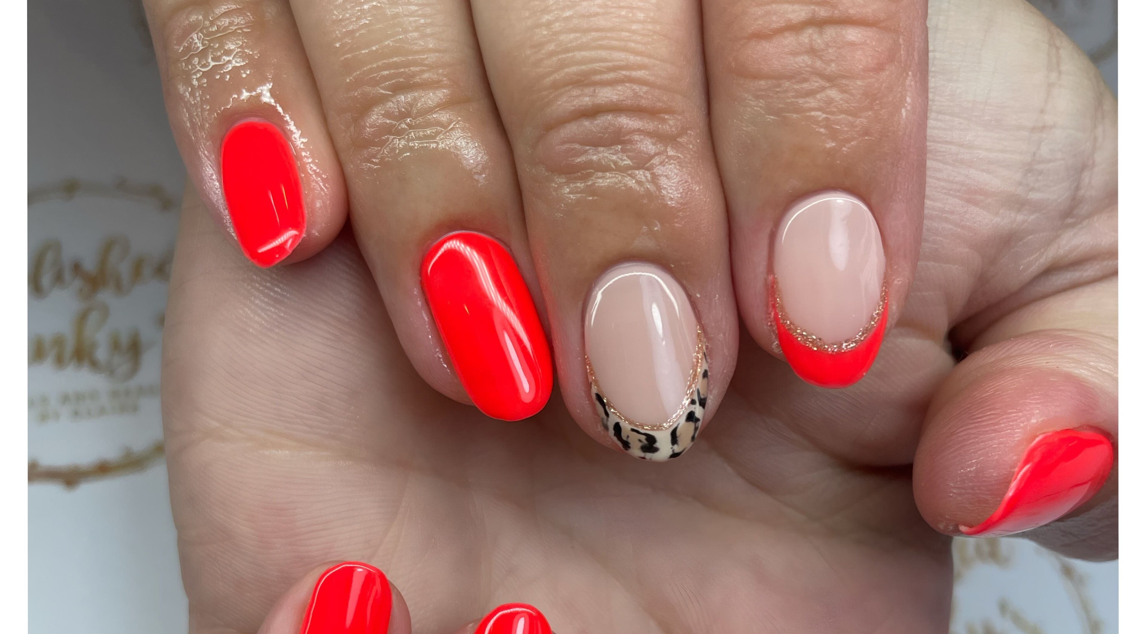 Stylish nail art with vibrant coral and leopard accents at Polished Pinky's, Taverham, England, GB.