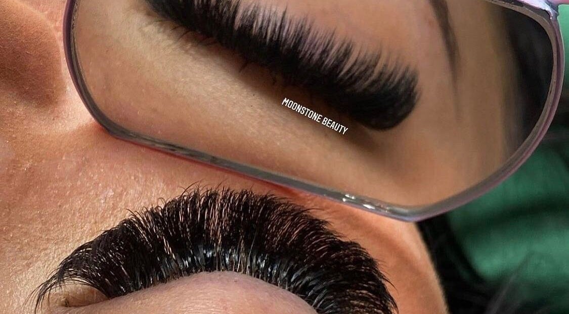 Close-up of eyelash extensions at Moonstone Beauty, Leopold, Victoria, AU, in a handheld mirror.