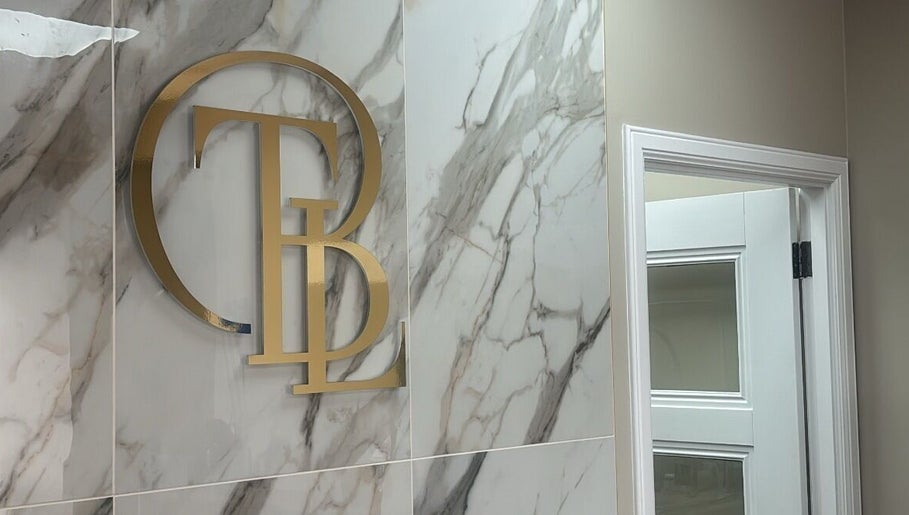 Elegant gold initials on a marble wall at The Beauty Lounge, Aberdeen, GB.
