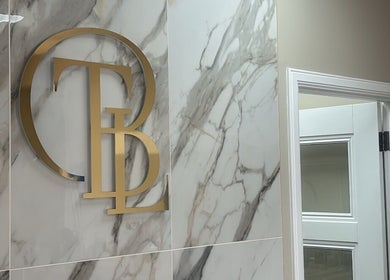 Elegant gold initials on a marble wall at The Beauty Lounge, Aberdeen, GB.
