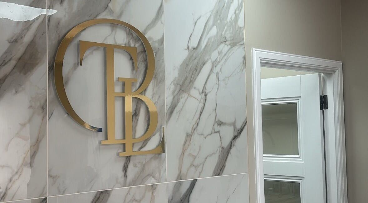 Elegant gold initials on a marble wall at The Beauty Lounge, Aberdeen, GB.