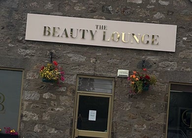 The Beauty Lounge exterior with stylish signage in Aberdeen, GB, showcasing rustic charm with floral accents.