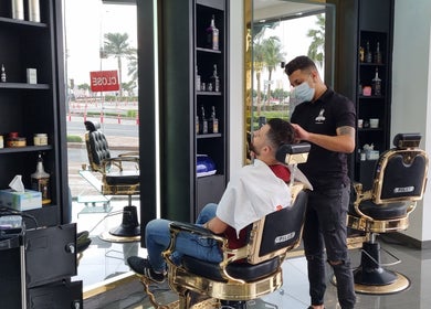 Hair stylist at Stile Di Capelli Gents Salon, Dubai, Dubai, AE, grooming a client in a chic interior.