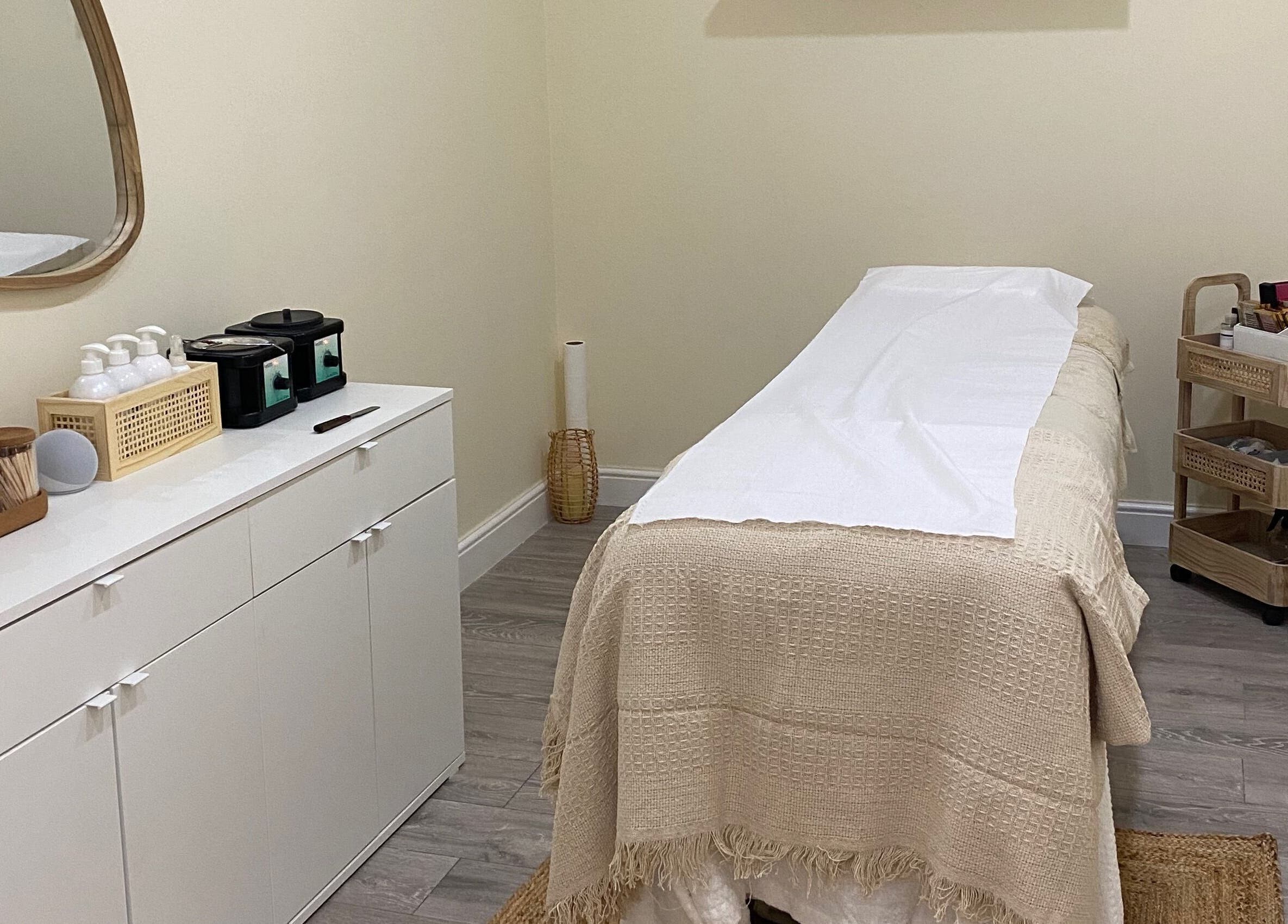Elegant treatment room at Oh So Pretty, Wigston, England, GB, featuring a cozy massage table and chic decor.