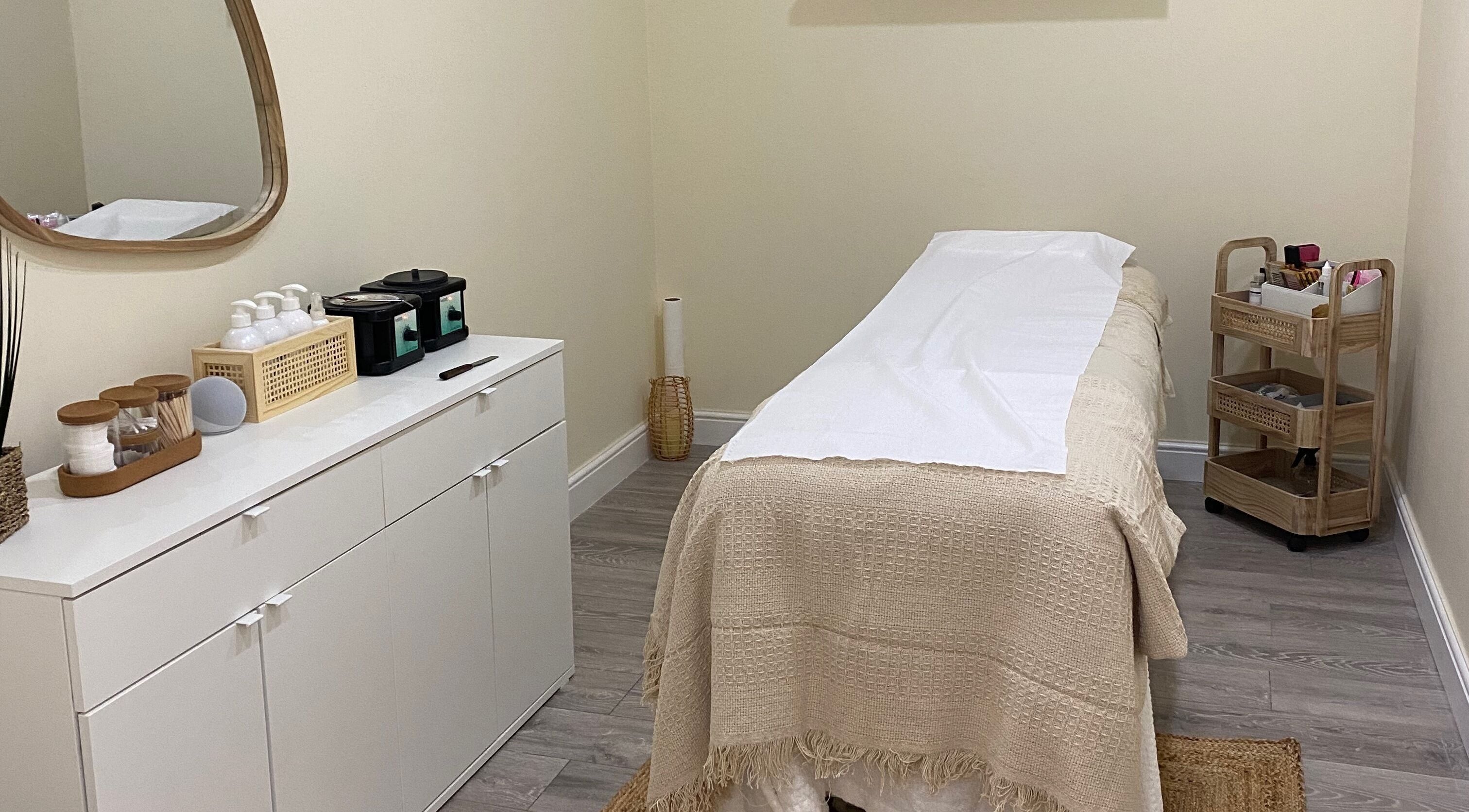 Elegant treatment room at Oh So Pretty, Wigston, England, GB, featuring a cozy massage table and chic decor.
