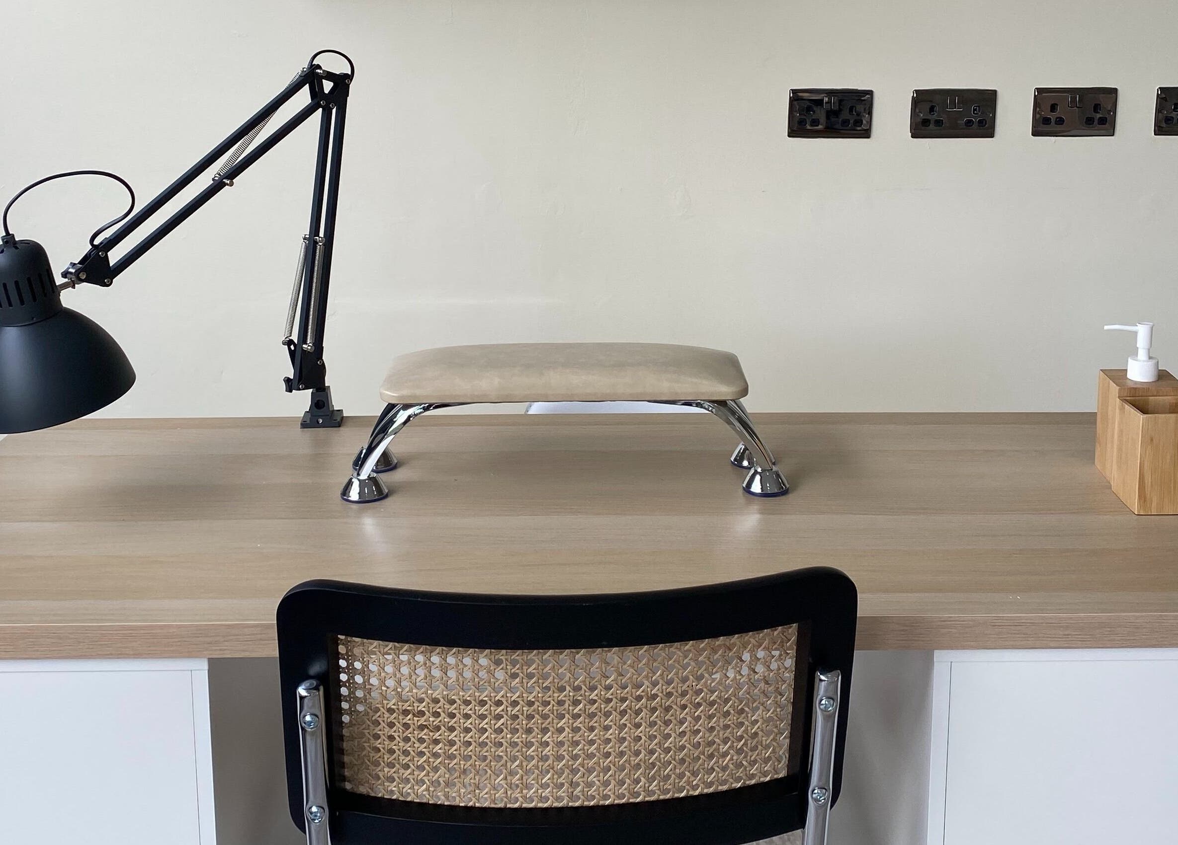 Modern nail care setup at Oh So Pretty, Wigston, England, GB with lamp, hand rest, and sanitizer.