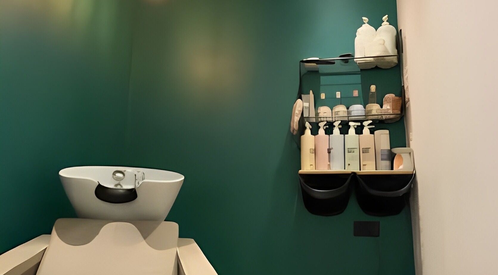 Create Salon's wash station in Cardiff, Wales, GB, with sleek green walls and beauty products displayed.