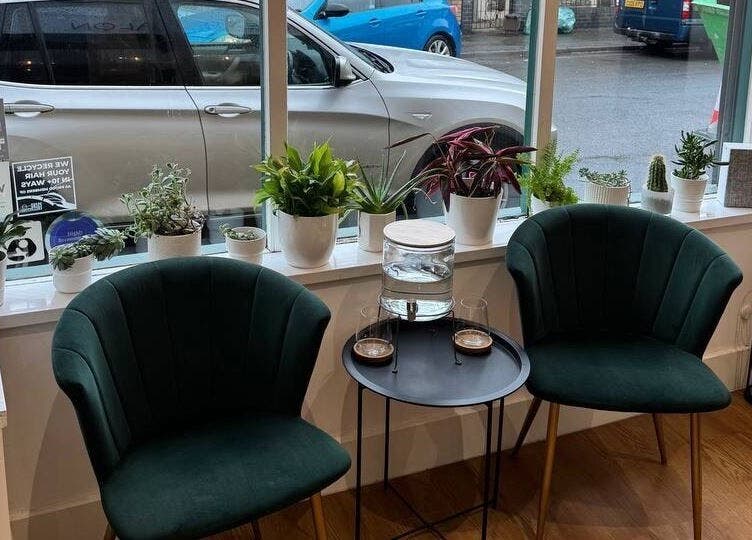 Inviting green chairs and plants at Create Salon, Cardiff, Wales, GB, offer a relaxing waiting area.