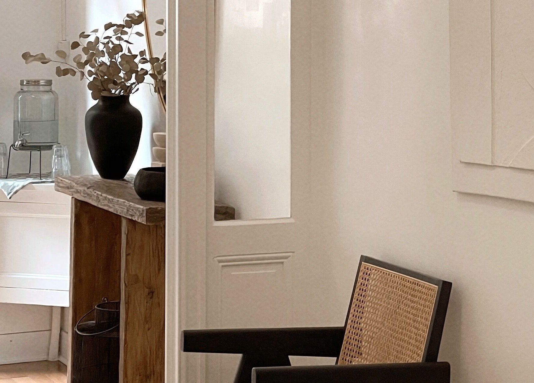 Intérieur minimaliste chez Call Me Sweet à Bordeaux, avec chaise en osier et vase décoratif moderne.