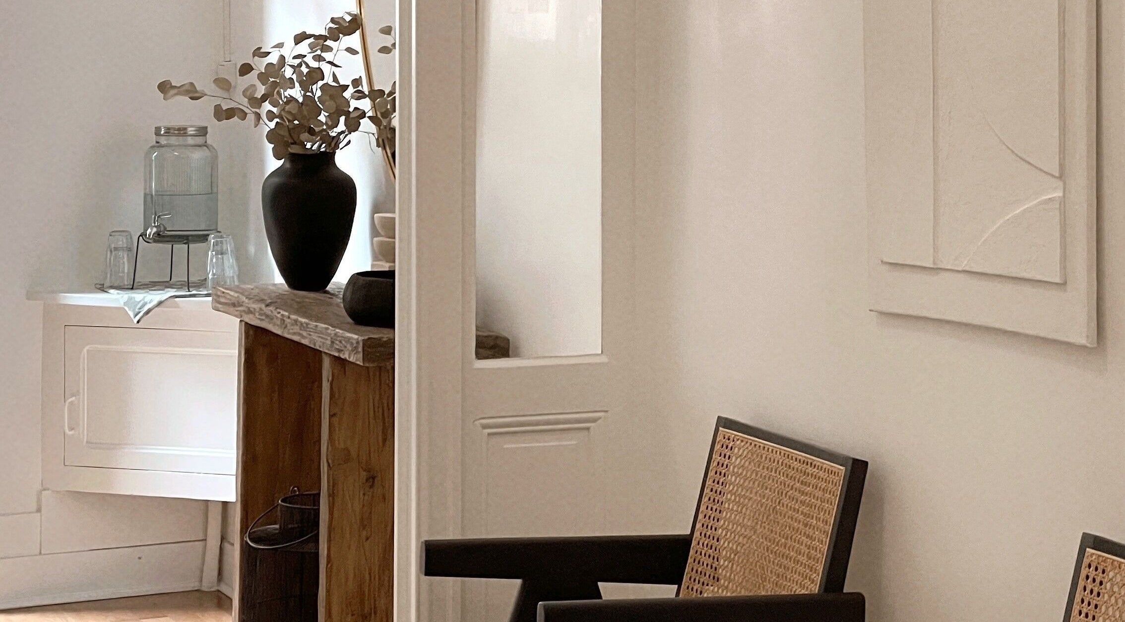 Intérieur minimaliste chez Call Me Sweet à Bordeaux, avec chaise en osier et vase décoratif moderne.