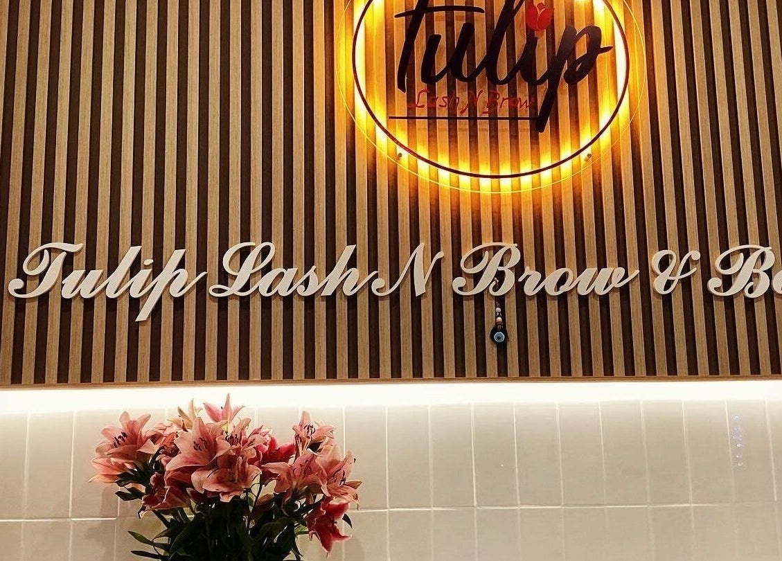 Tulip Lash n Brow entrance in Baulkham Hills, NSW, featuring elegant signage and fresh flowers.