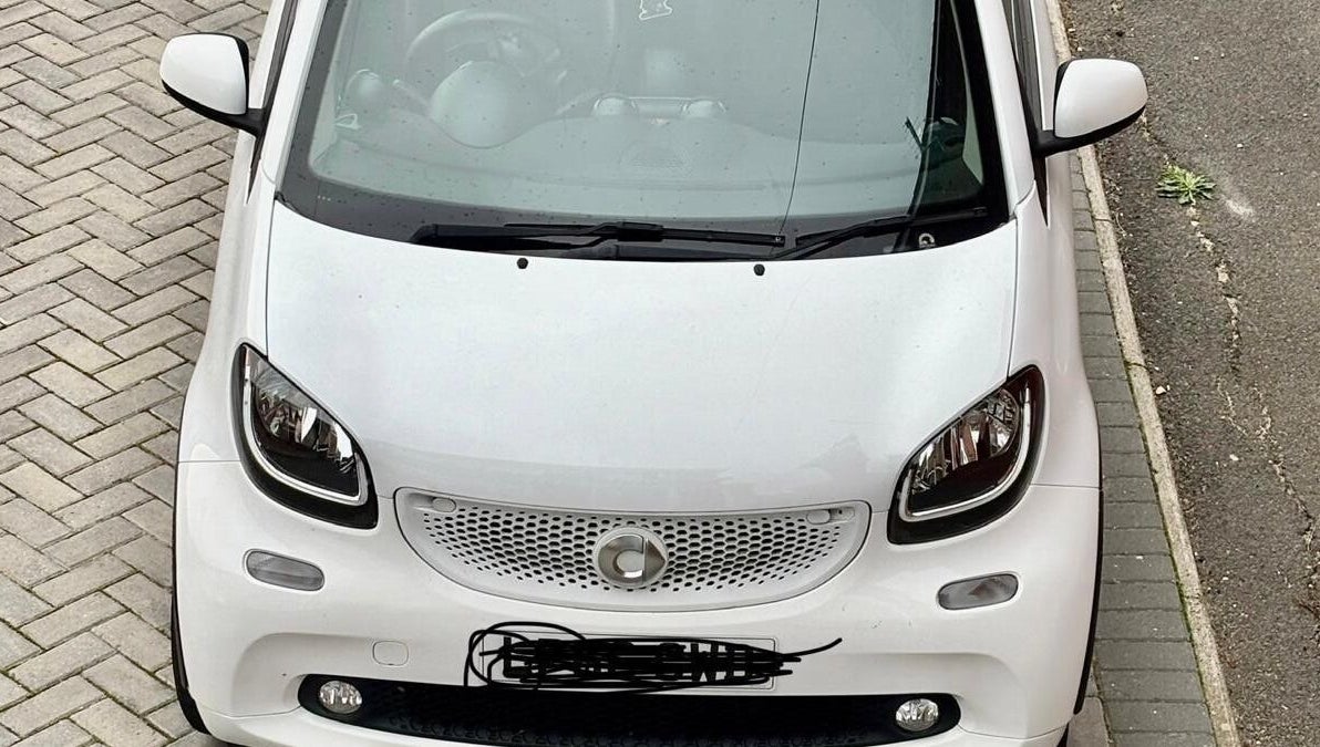 White car parked outside Funky Feet in Weymouth, England, GB, highlighting urban charm.