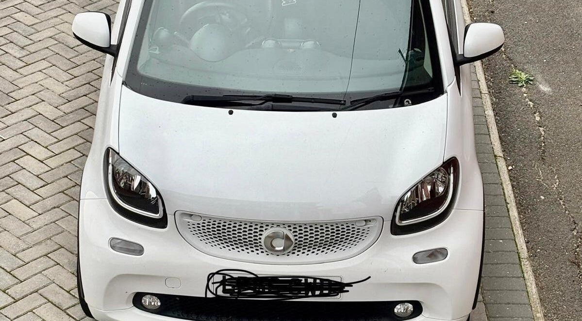 White car parked outside Funky Feet in Weymouth, England, GB, highlighting urban charm.
