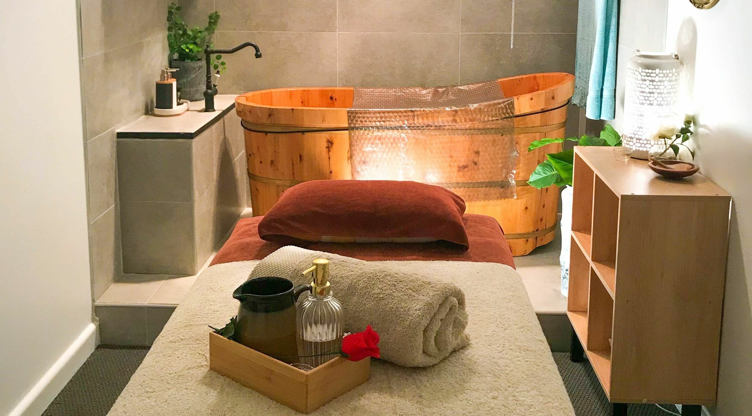 Relaxing spa room at Kamiya Day Spa, Ashburton, Victoria, AU with massage bed and wooden tub for ultimate tranquility.