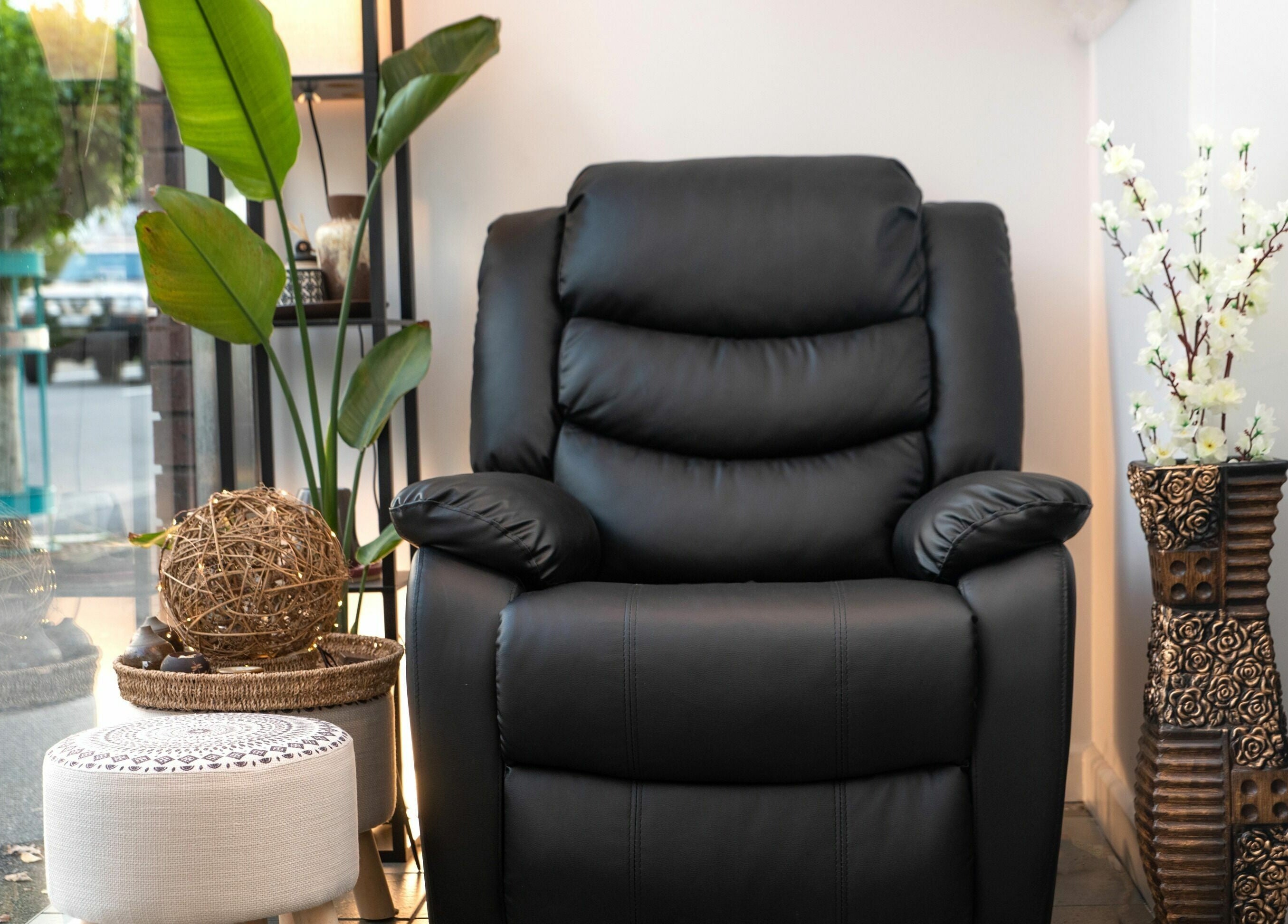Elegant black massage chair at Kamiya Day Spa in Ashburton, Victoria, AU, surrounded by lush plants.