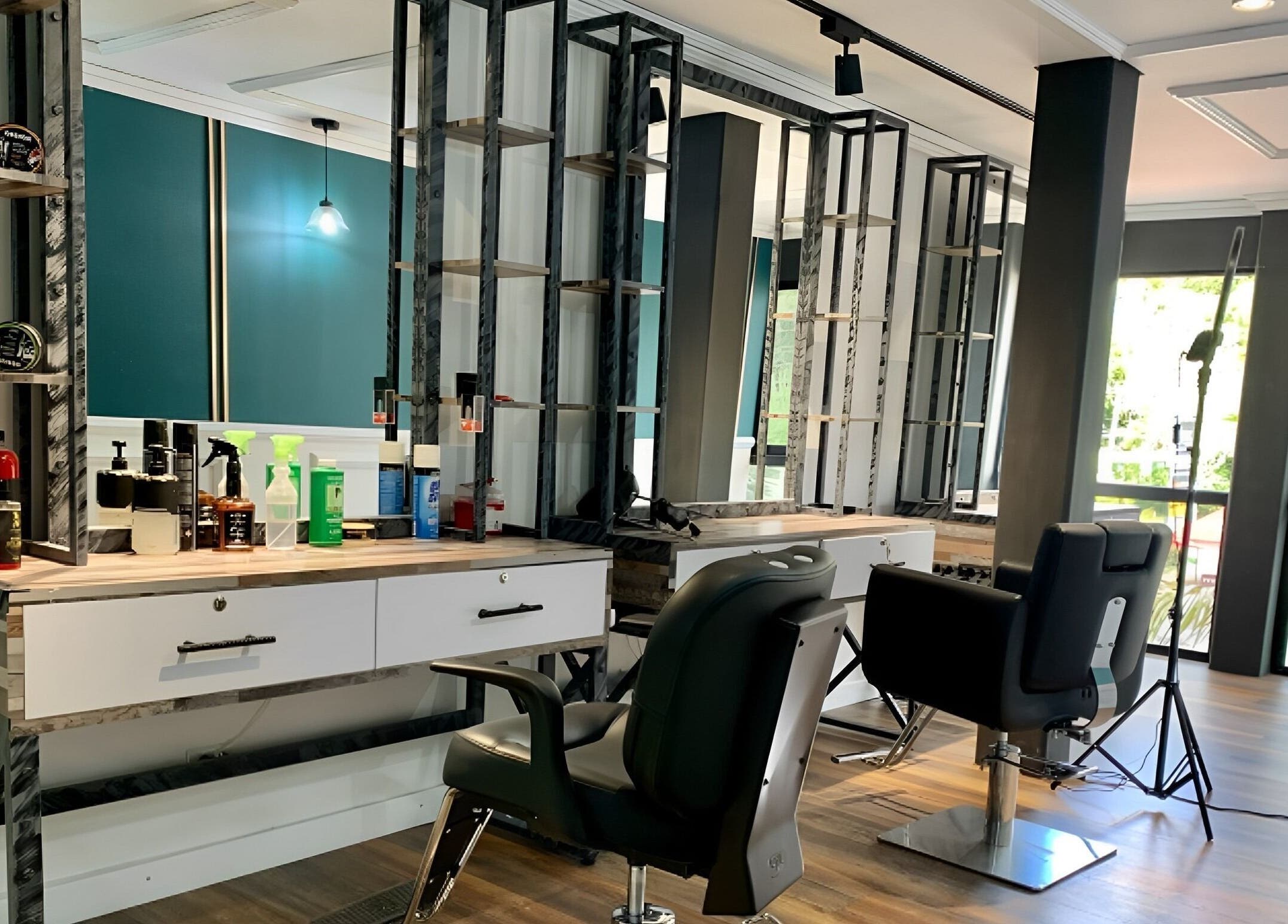 Interior del salón B-Stetic en Rionegro, Antioquia, CO; sillones de peluquería y espejo iluminado.