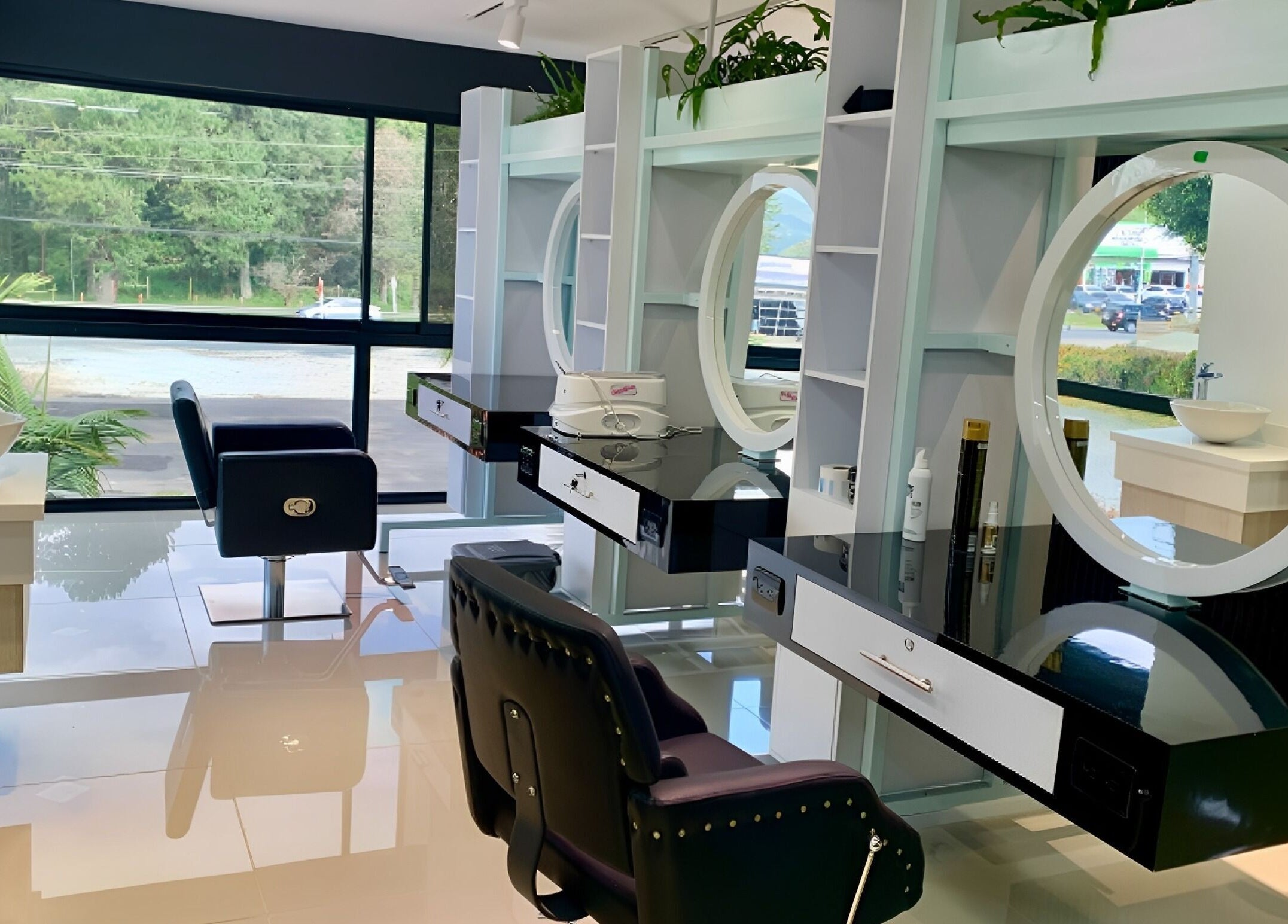 Interior moderno de B-Stetic en Rionegro, Antioquia, CO con espejos circulares y sillas de lujo.