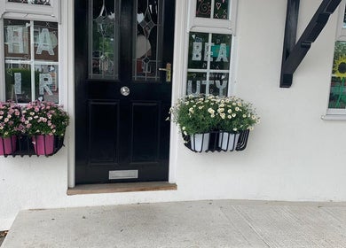 Front entrance of The Salon in Bollington, United Kingdom, GB with vibrant floral displays.