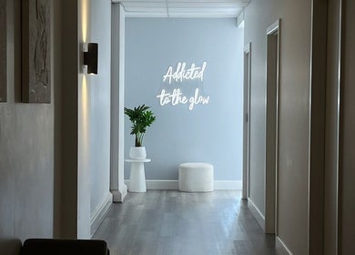 Hallway at Vanish Laser & Skin, Melbourne with a glowing sign reading 'Addicted to the glow'.