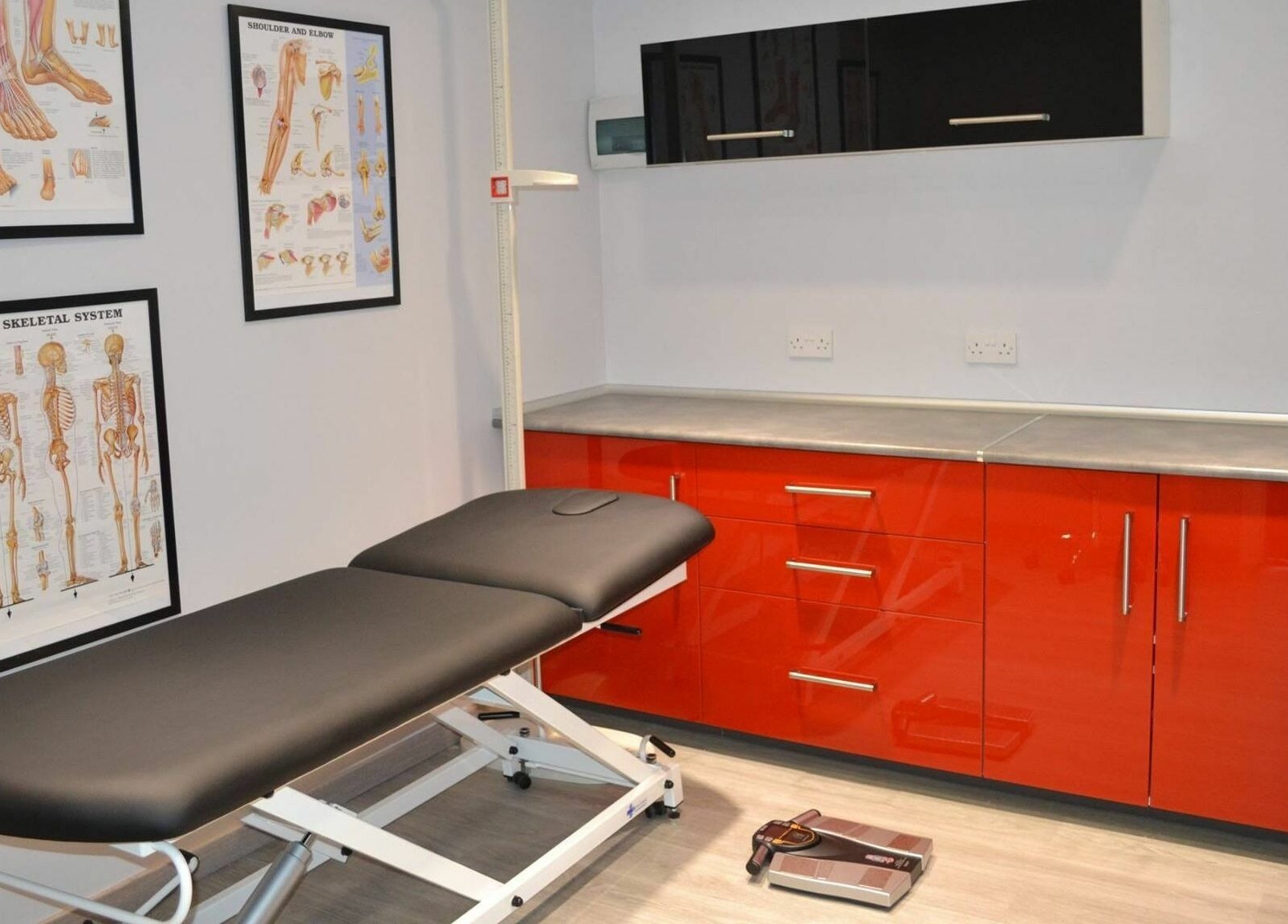 Modern treatment room at Activ Sports Medicine and Performance Clinic, Gibraltar, GI with sleek red cabinets.