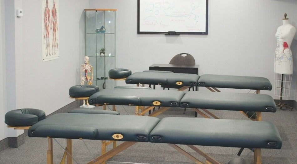 Salle de massage à École de Massage À Fleur De Peau, Montréal, Québec, CA avec tables et matériel éducatif.