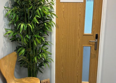 Entrance of Coach Collins - The 1:1 Diet, featuring wooden door and lush plants in Southampton, England, GB.