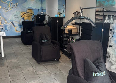Stylish interior of Lovelli Salon & Training Academy in Halfway, England, GB, featuring cozy chairs and artful decor.