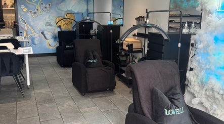 Stylish interior of Lovelli Salon & Training Academy in Halfway, England, GB, featuring cozy chairs and artful decor.