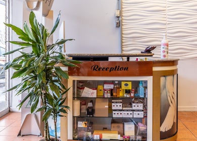 Reception desk at Spa ManiPedi, Côte Saint-Luc, Québec, CA, showcasing beauty products and greenery.