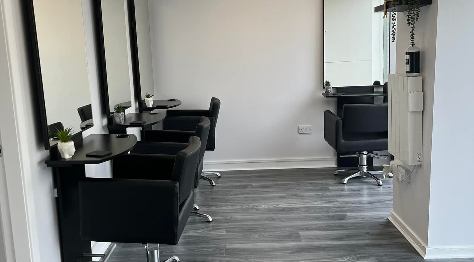 Stylish salon setup at Ashleah Marie Hairdressing, Stirling, Scotland, GB, featuring modern black chairs and mirrors.