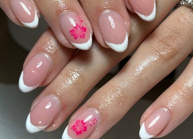 Stylish nail art at Agi’s Nails in Thurso, Scotland, GB showcasing pink polish with white tips and pink flowers.