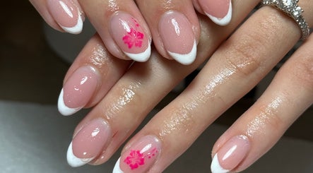 Stylish nail art at Agi’s Nails in Thurso, Scotland, GB showcasing pink polish with white tips and pink flowers.