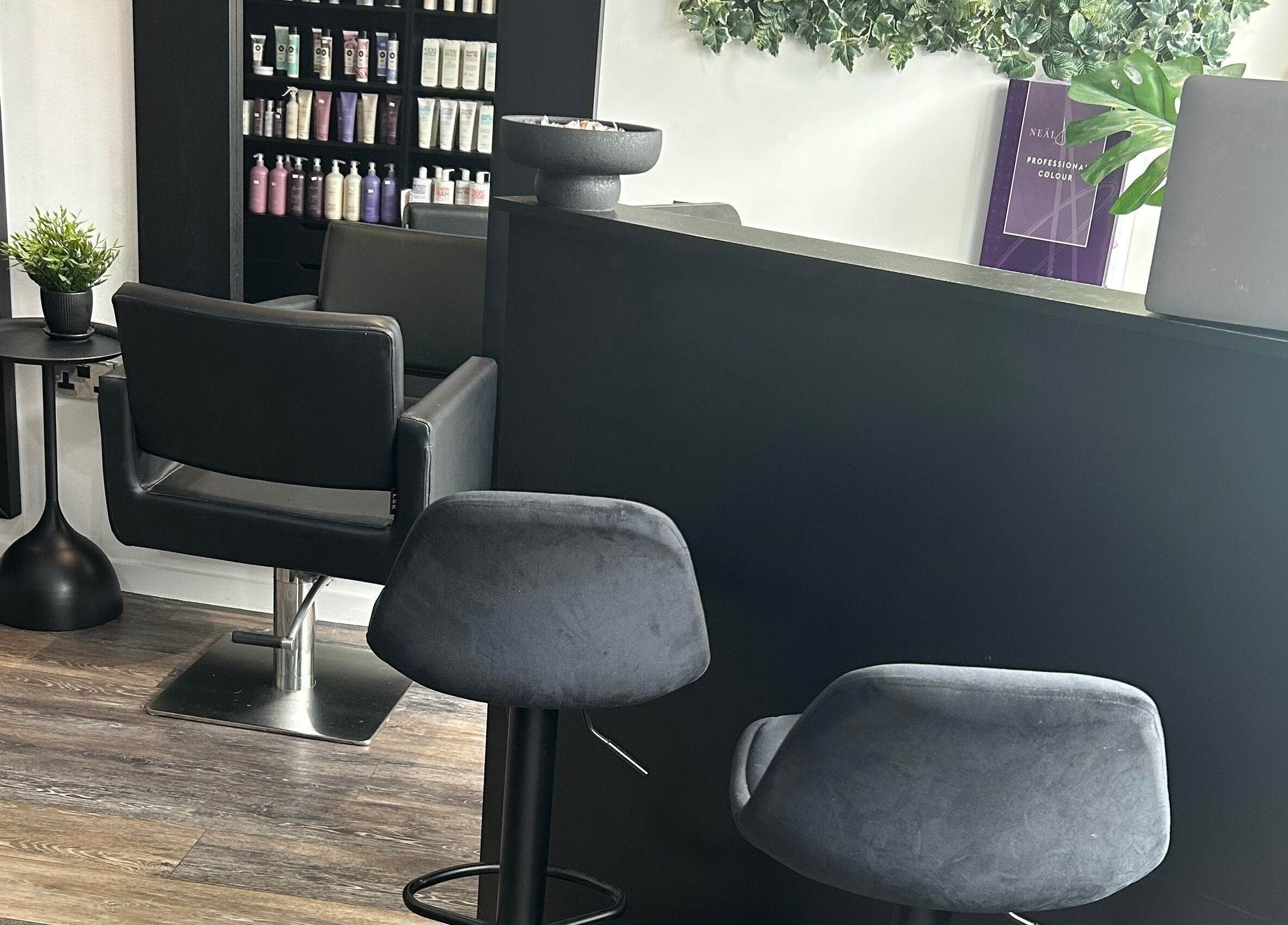 Modern salon reception area at Hair and Beauty Gallery, Blackburn, England, GB, showcasing sleek chairs and decor.