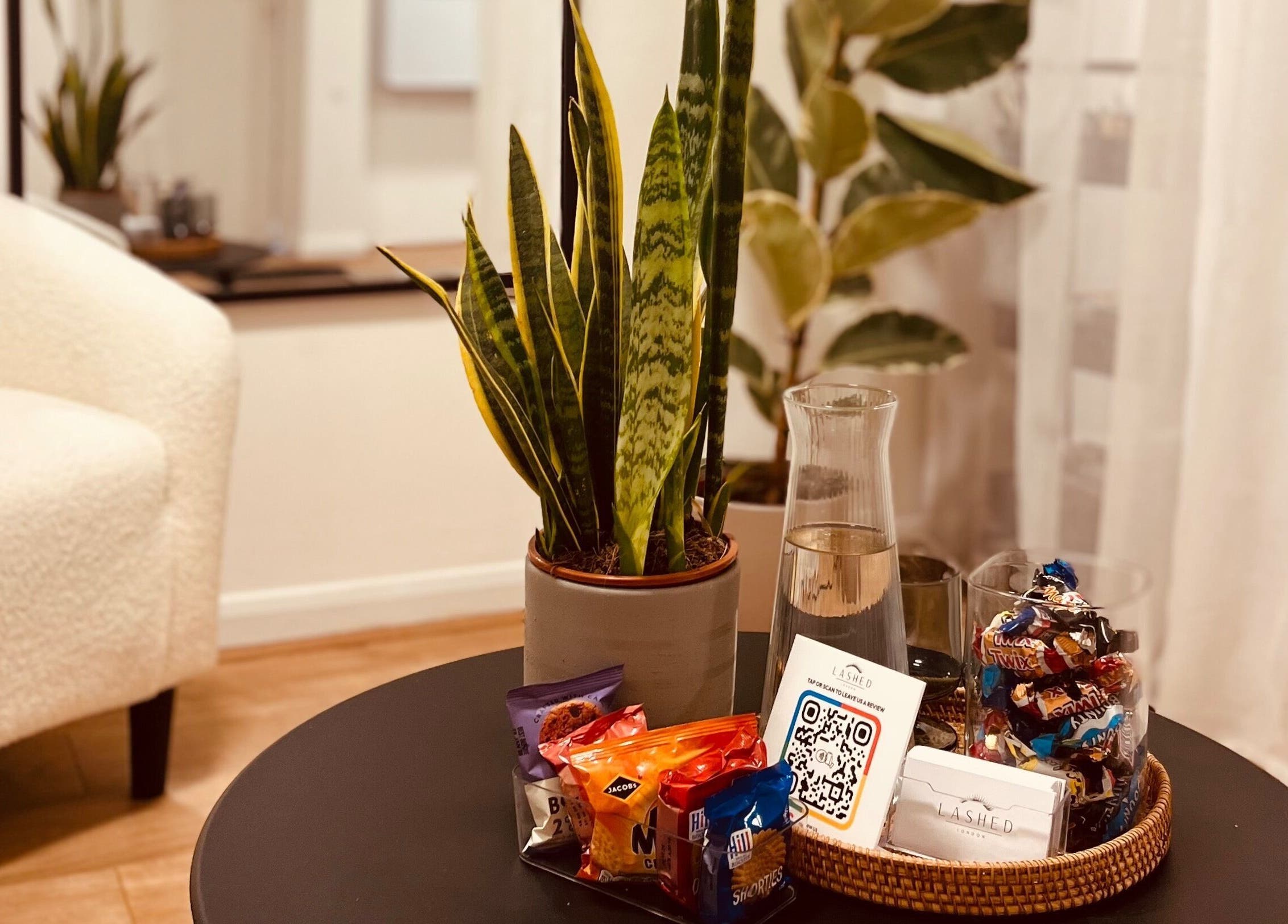Inviting corner at Lashed in London featuring a plant, snacks, and decor in London, England, GB.