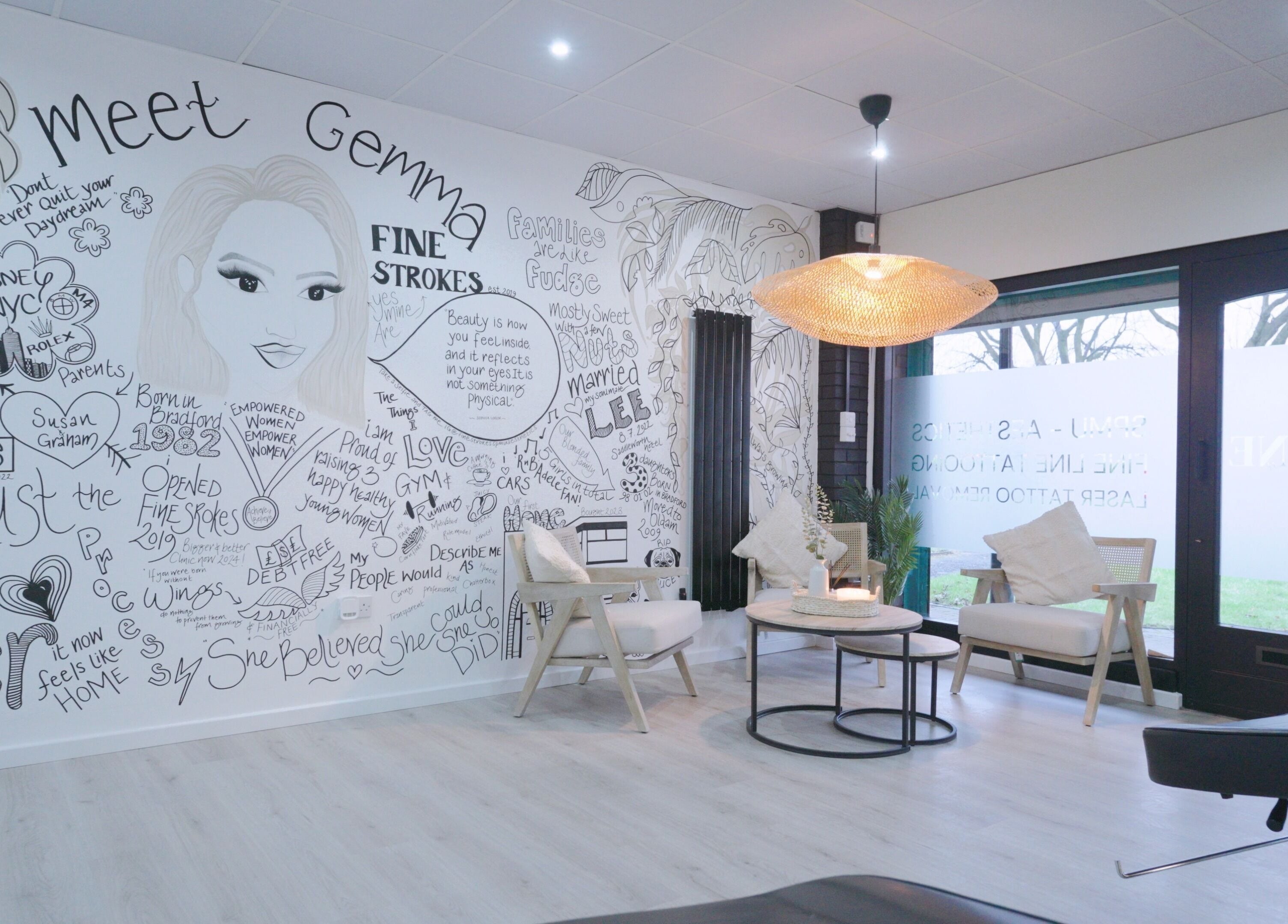 Artistic lounge area at Fine Strokes SPMU and Aesthetics, Chadderton, England, featuring unique mural design.