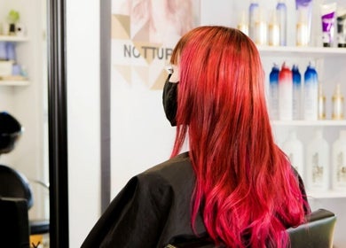 Red-haired woman at Platinum Hair Plumstead in Cape Town, Western Cape, ZA. Salon products visible in the background.