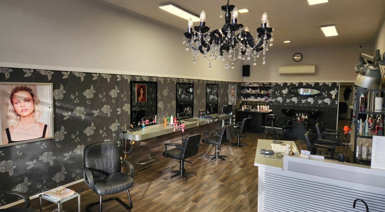 Chic interior of Chris and Co Hair Design, Pukekohe, Auckland, NZ with modern styling stations and chandelier.