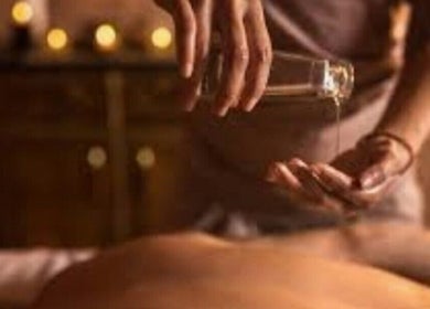 Relaxing massage oil being poured at The Goddess Loft, Nassau, New Providence, BS for a soothing wellness experience.