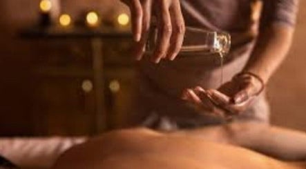 Relaxing massage oil being poured at The Goddess Loft, Nassau, New Providence, BS for a soothing wellness experience.