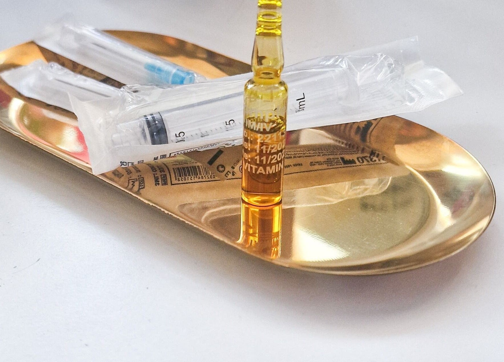 Golden tray with vitamin ampoule at RD Nails & Beauty Clinic, Peterborough, Cambridgeshire, GB.