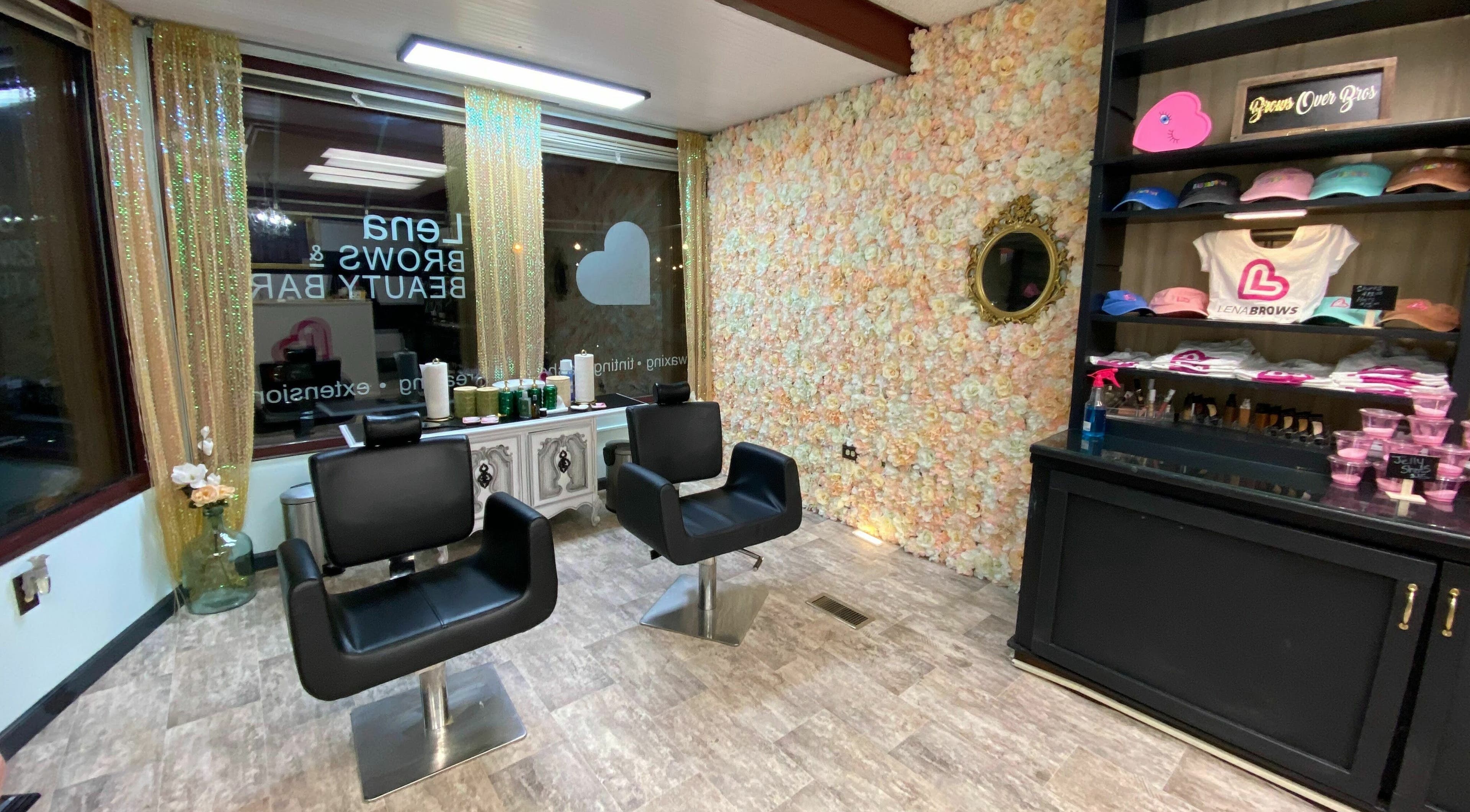 Modern salon chairs in Lena Brows and Beauty Bar, Sandusky, Ohio, US, with floral wall and product display.