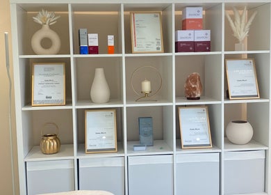 Elegant shelves at Bespoke Skin, Hoddesdon, England showcasing certificates and decor.